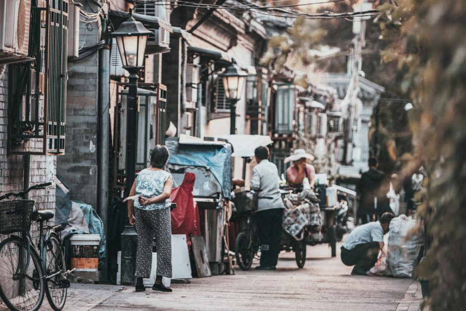 A glimpse into the vibrant street life of a traditional hutong in Beijing, China, showcasing daily interactions.